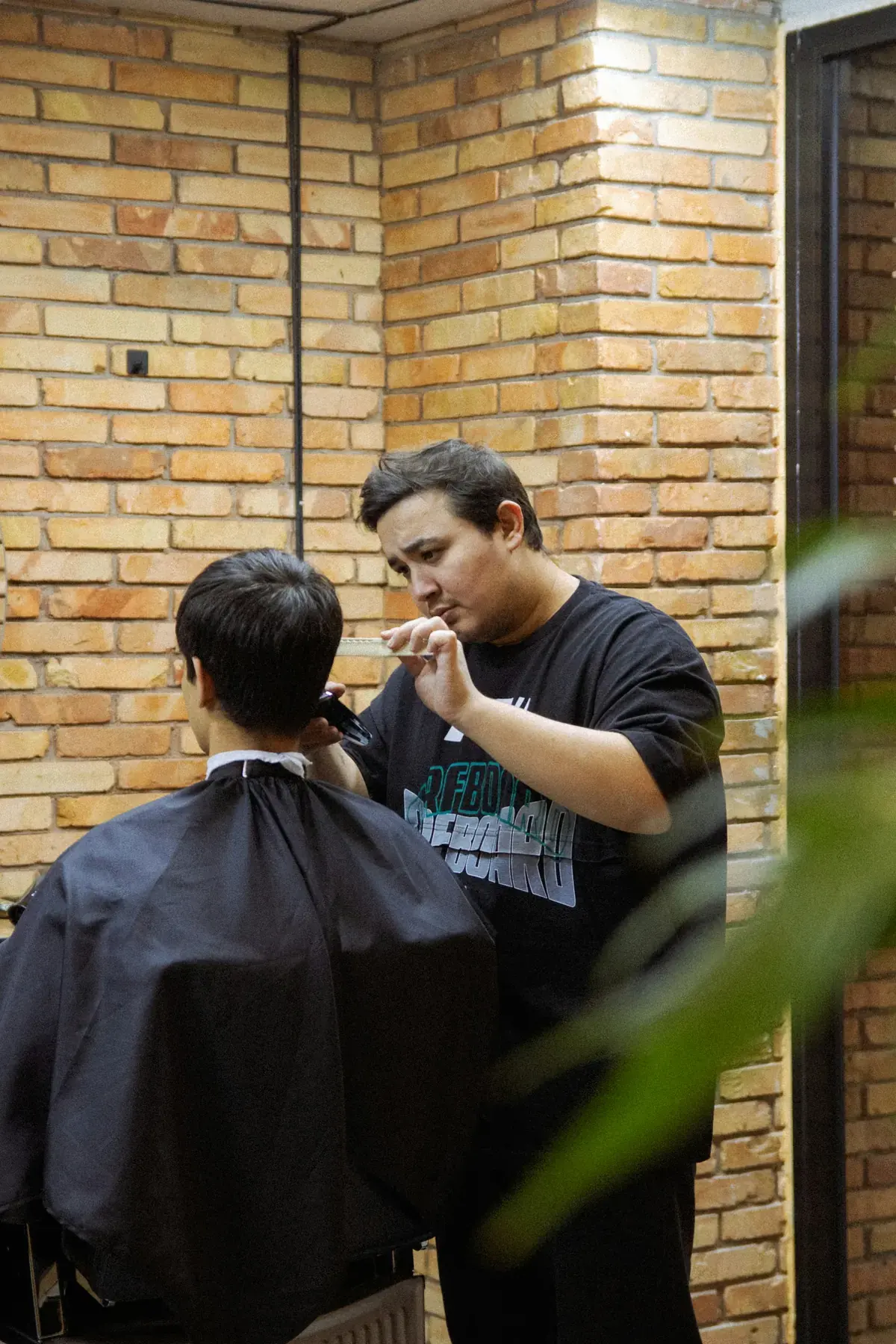 A barber shaping a client’s haircut with clippers